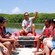 A guide speaks to people on an inflatable boat near a mangrove forest